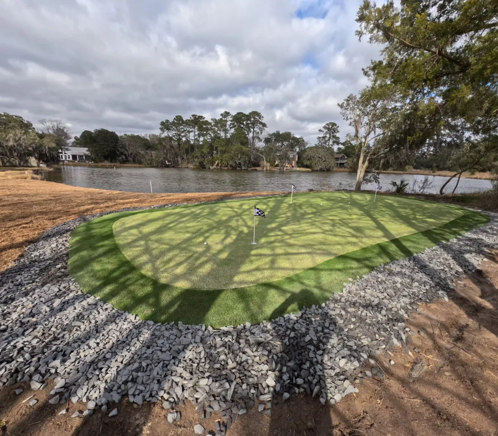 Waterfront artificial turf putting green with three flags and a slate border in Charleston, SC