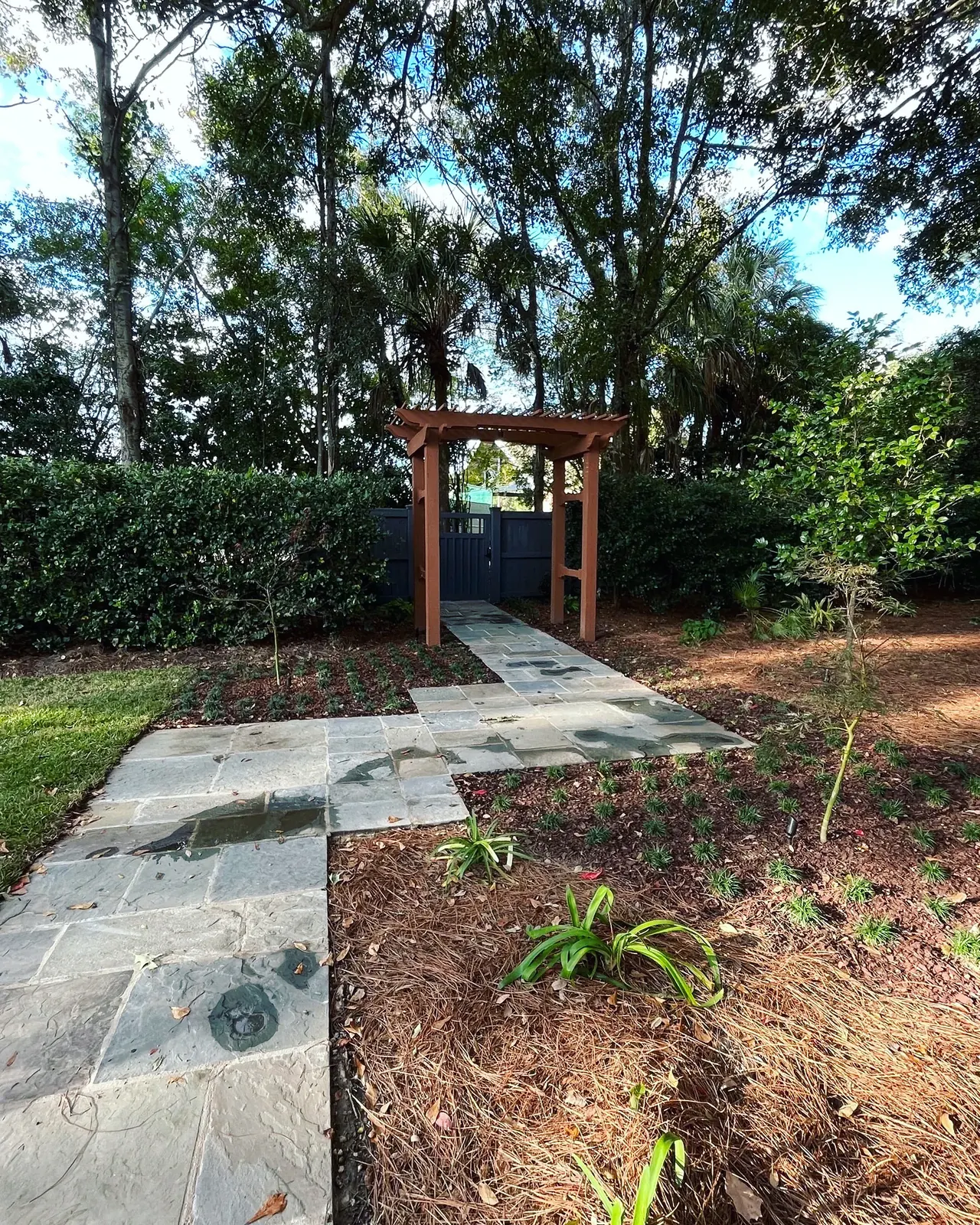 Wooden arbor bluestone walkway in James Island, SC Wooden arbor over a bluestone walkway with new plantings in James Island, SC