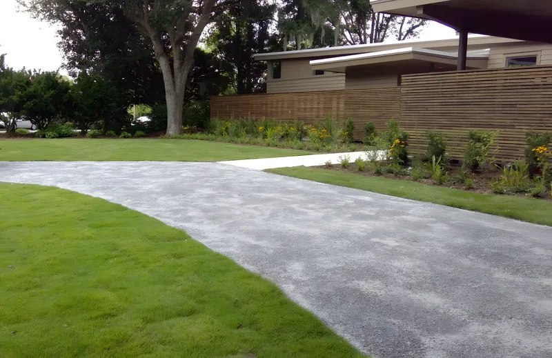 Plantation mix gravel driveway with metal edging and a horizontal slat fence in Mount Pleasant, SC