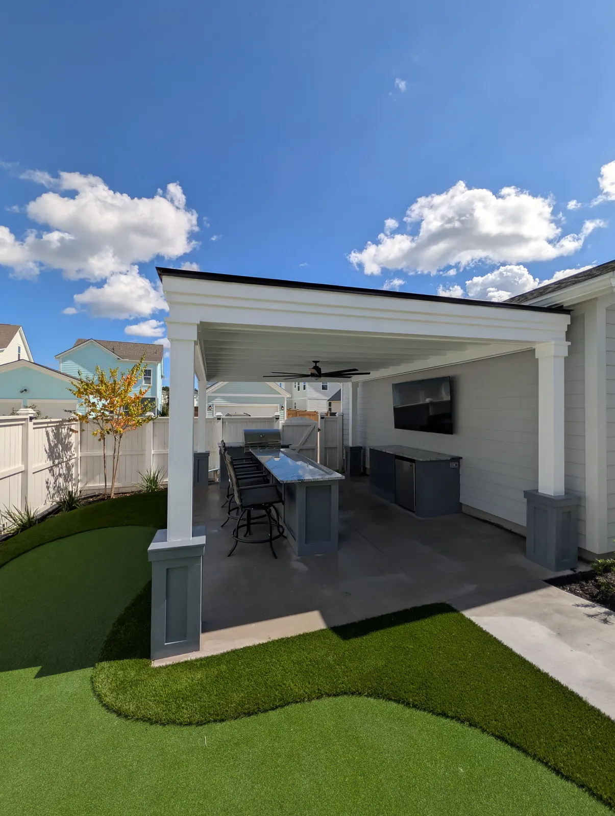 Backyard outdoor living space with pergola and putting green in Summerville, SC
