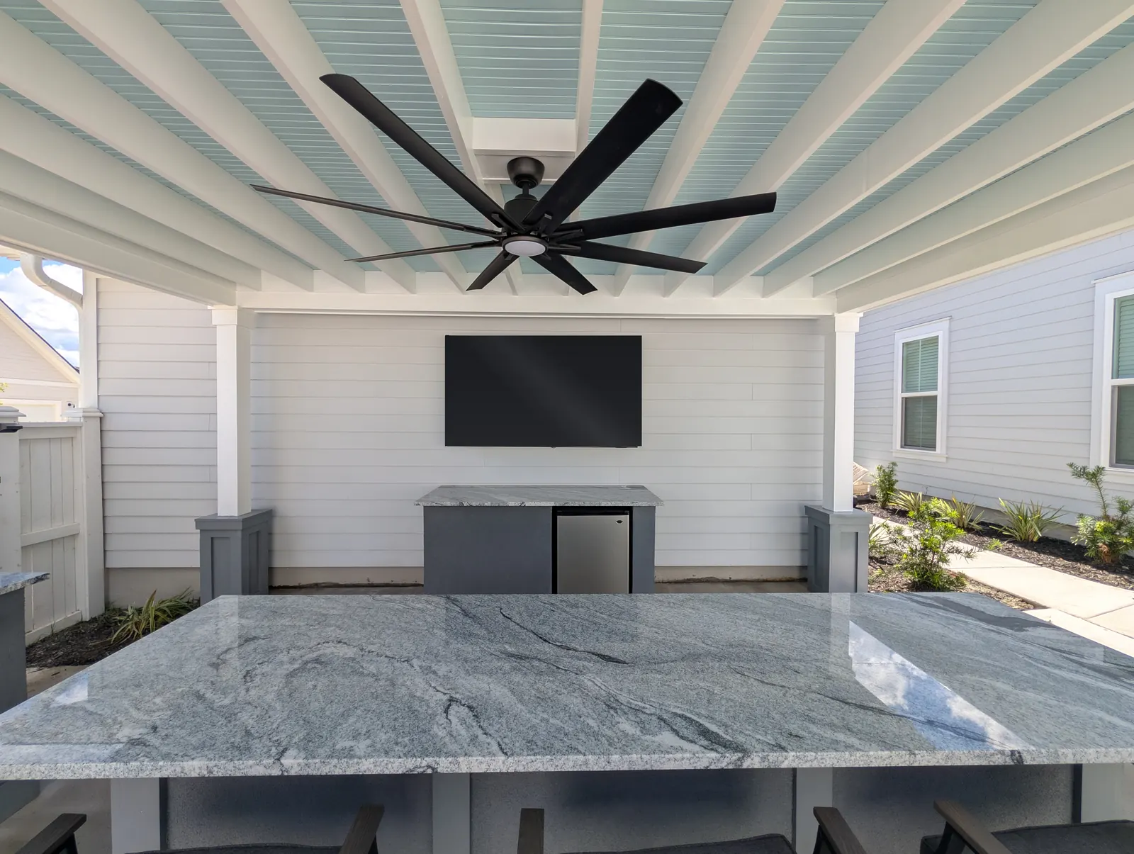 Granite outdoor kitchen countertop facing a mounted TV in Summerville, SC