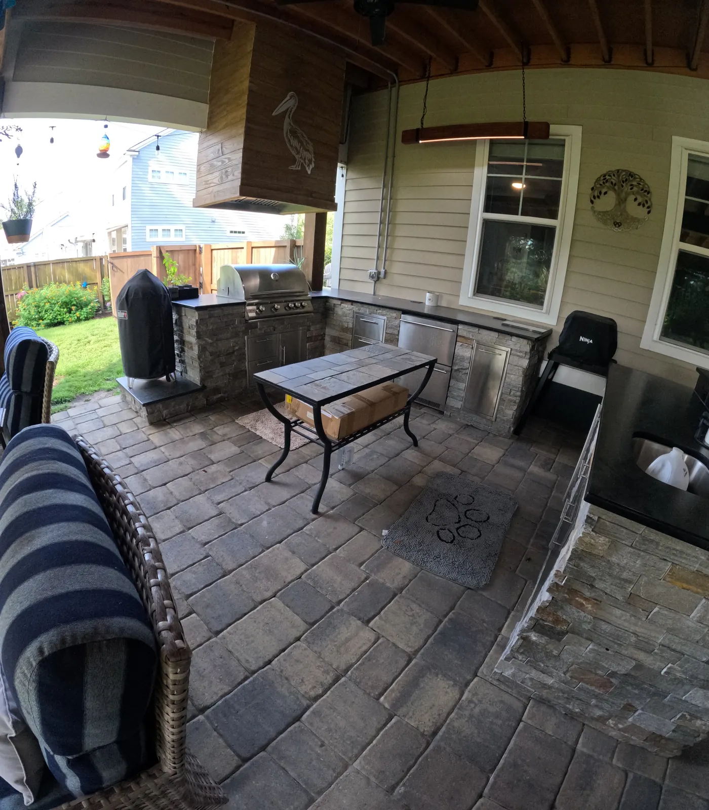 Stone outdoor kitchen with a grill and smoker on a paver patio in Summerville, SC