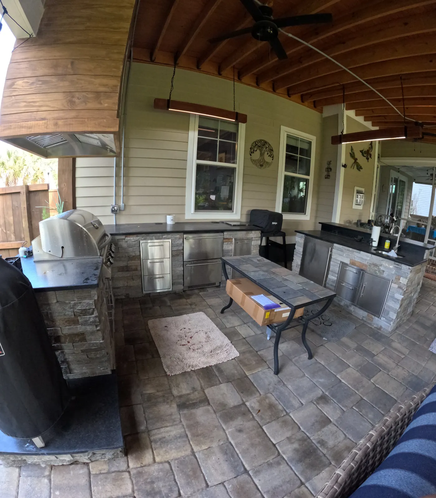 Stone outdoor kitchen with stainless cabinetry under a covered porch in Summerville, SC