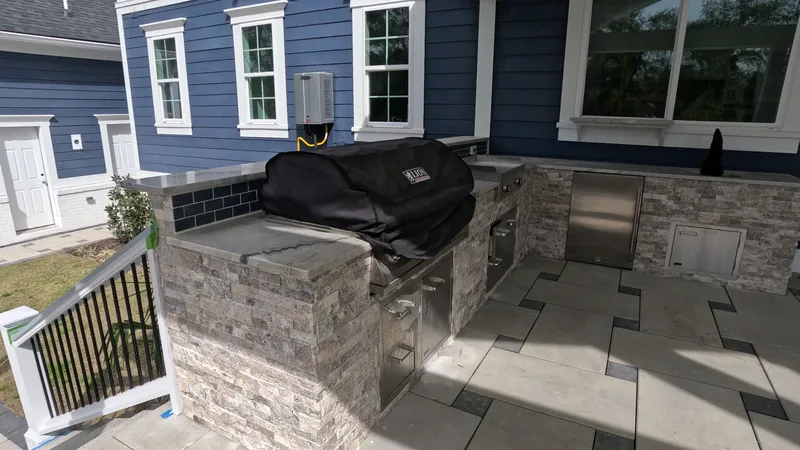 Stone outdoor kitchen with a built-in grill on a raised patio in Summerville, SC