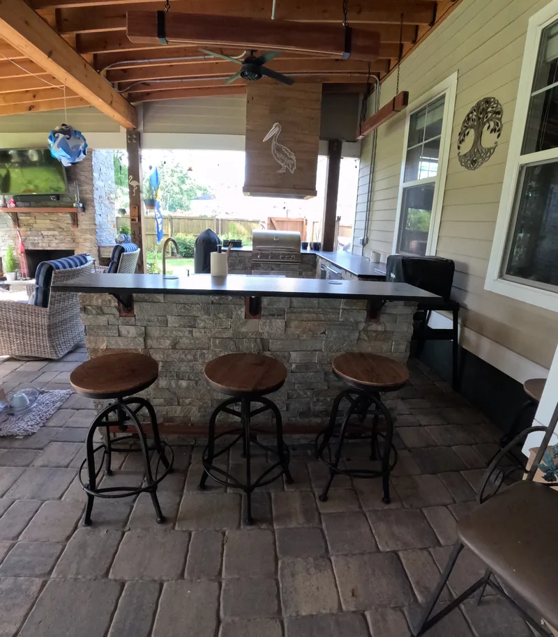 U-shaped ledgestone outdoor kitchen with a bar under a porch addition in Summerville, SC